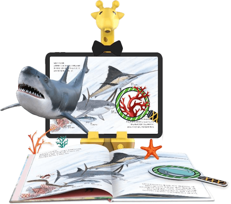 The Spotty stand, a yellow giraffe-shaped tablet holder, with a tablet showing a shark swimming out of an open picture book beneath it
